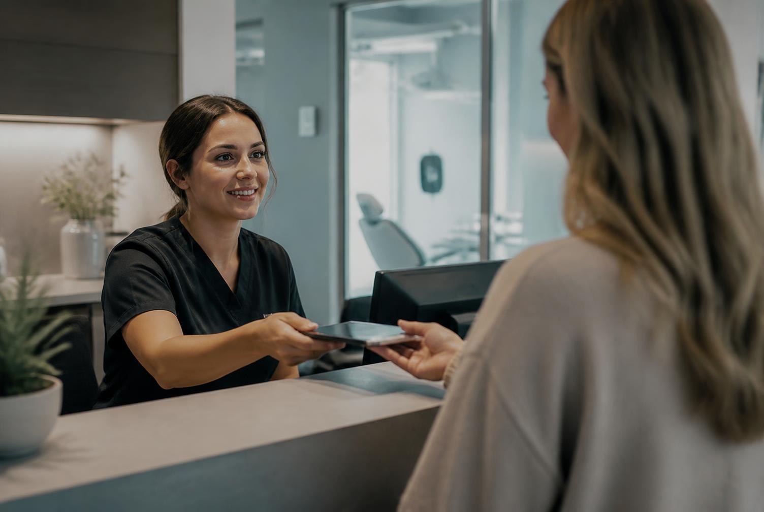 A dental office receptionist checking in a patient
